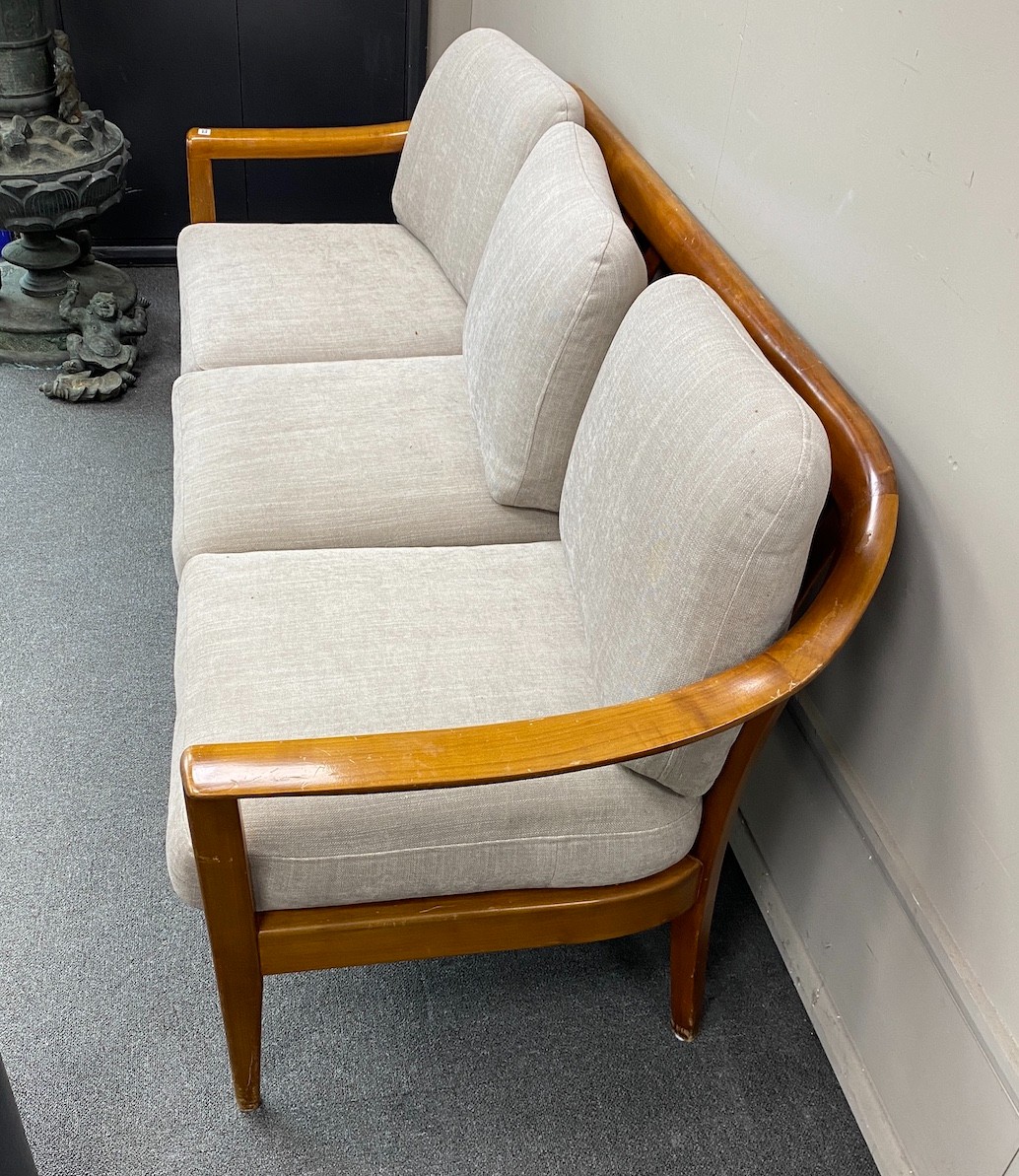 A mid century Wilhelm Knoll cherry three seater settee with loose cushion seats and backs.